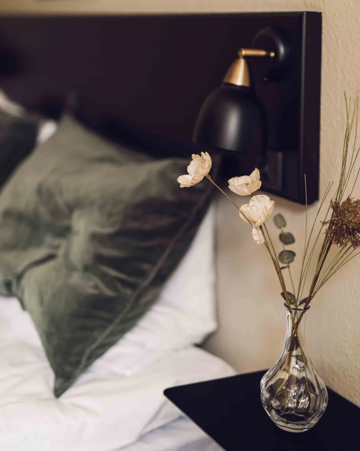 Detalje fra et værelse med lampe og blomster