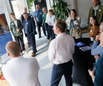 Deltagere fra dansk og tysk erhvervsliv står samlet i et lokale til et Business DE-DK-arrangement