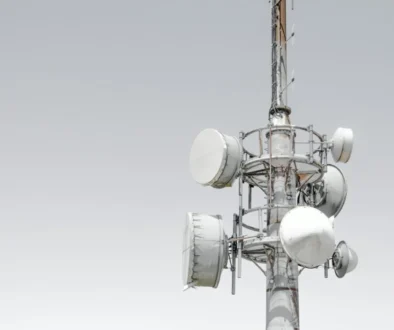 Mobilmast med antenner mod en lys himmel